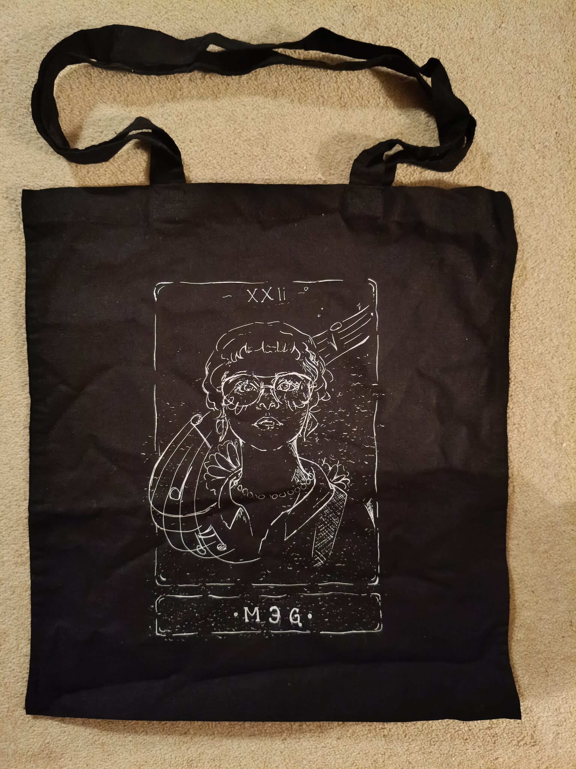 Black tote bag with white printed image of meg